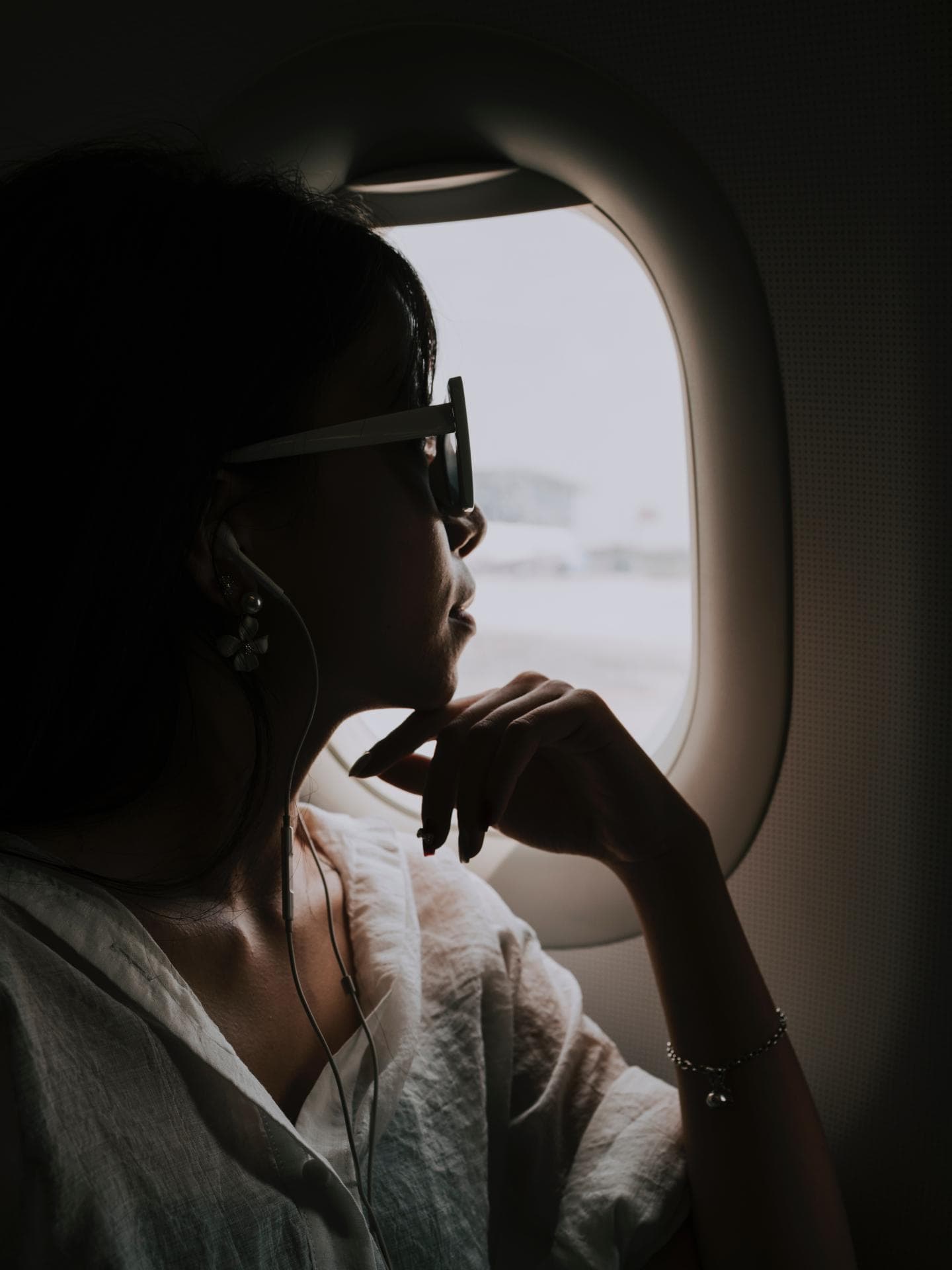 Frau sitzt im Flugzeug am Fenster