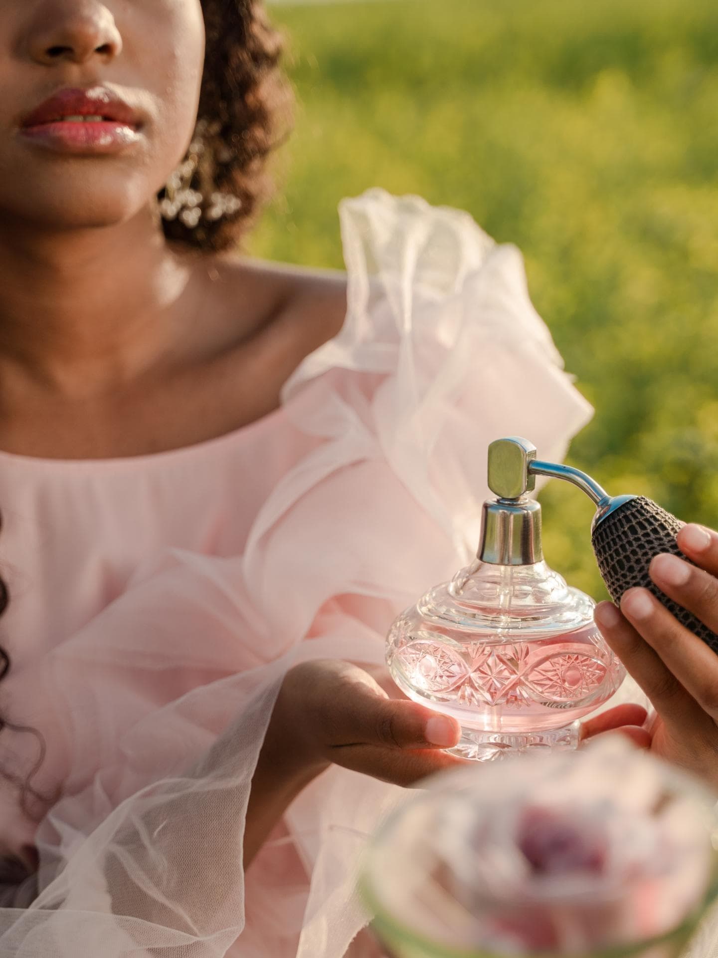 Frau hält rosa Parfum Flakon in der Hand