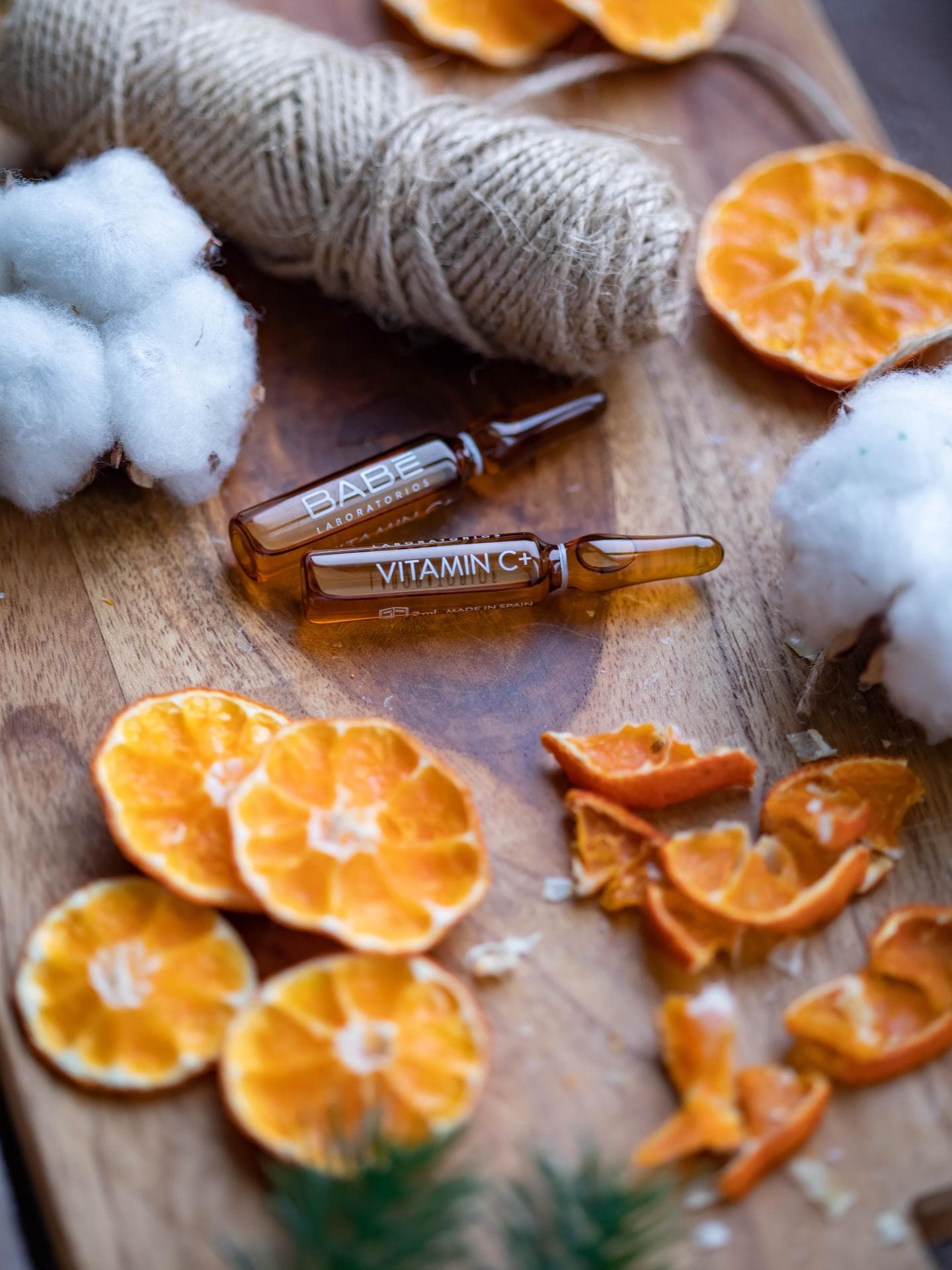 Vitamin C Seren Flakons neben getrockneten Orangen