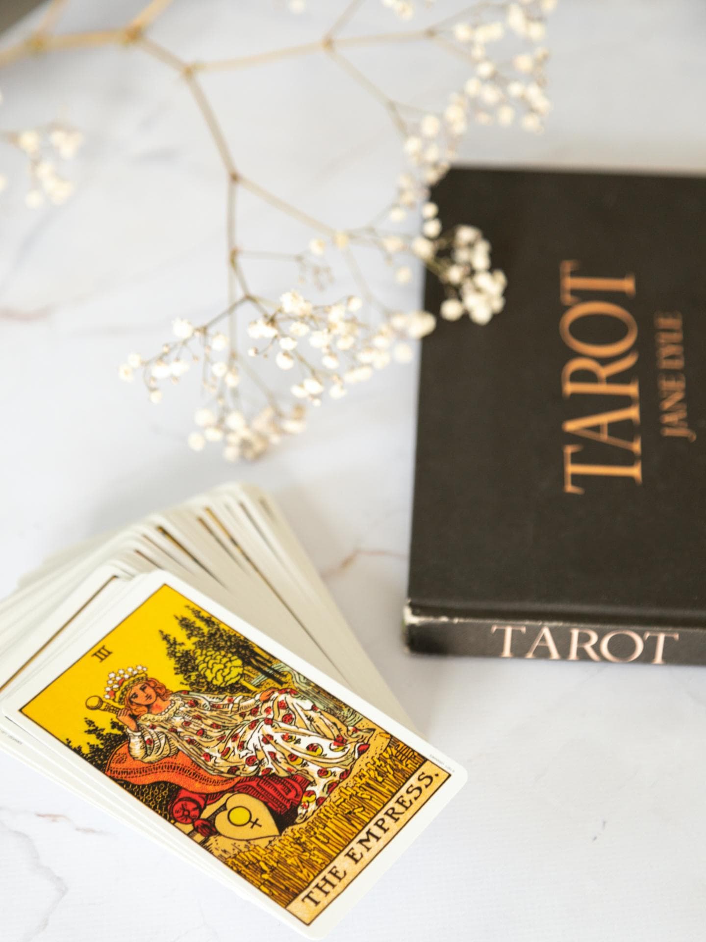 Tarot karten und ein Tarot Buch liegen auf einem Tisch