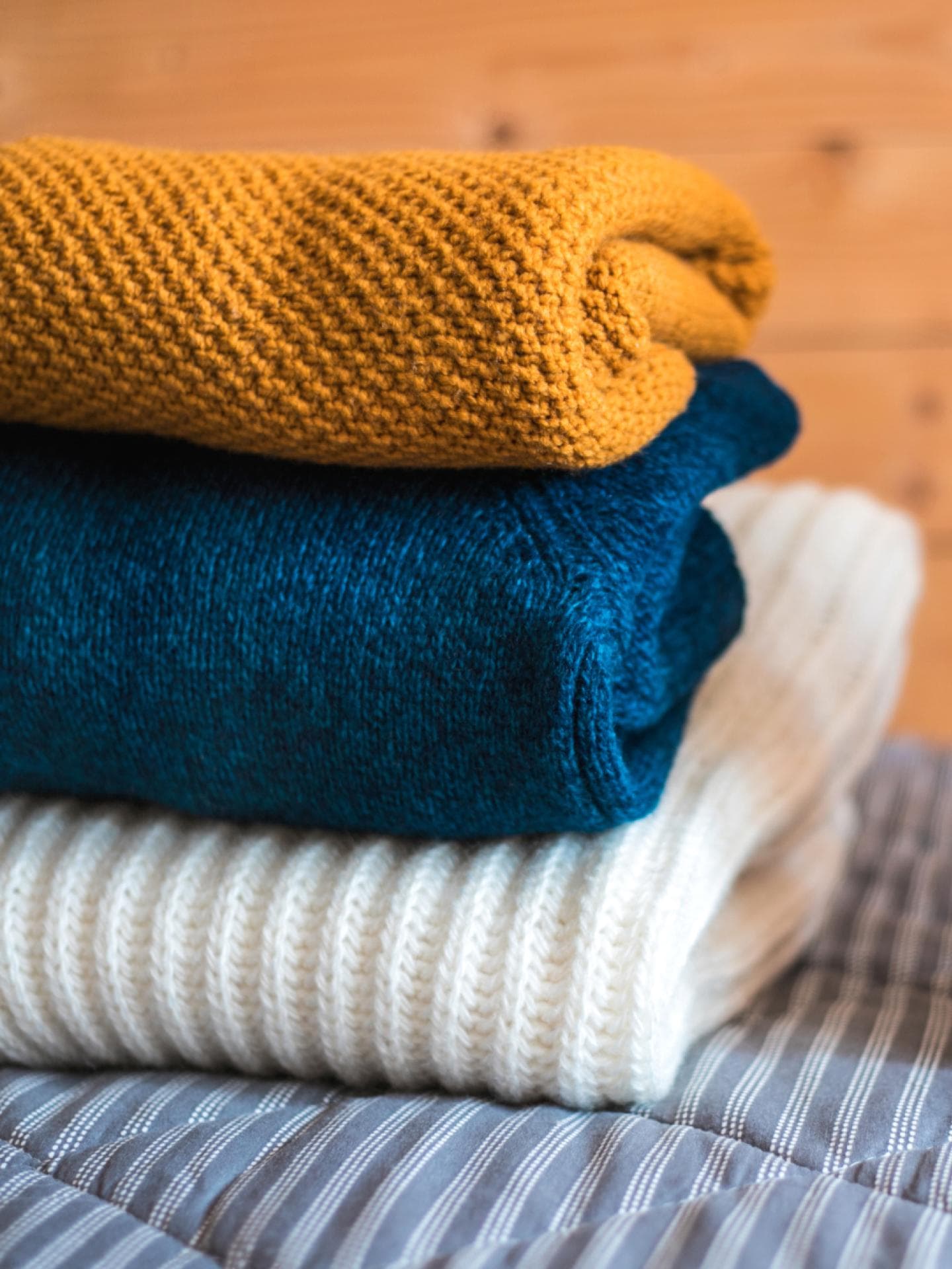 Drei Wollpullover mit Waschmittel Wolle waschen Tipps und Tricks