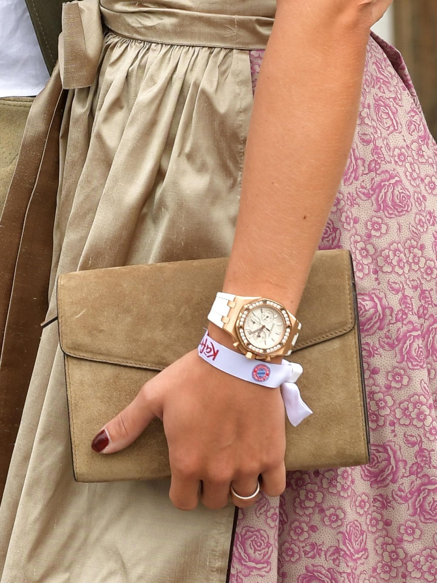 Frau trägt Uhr und Clutch