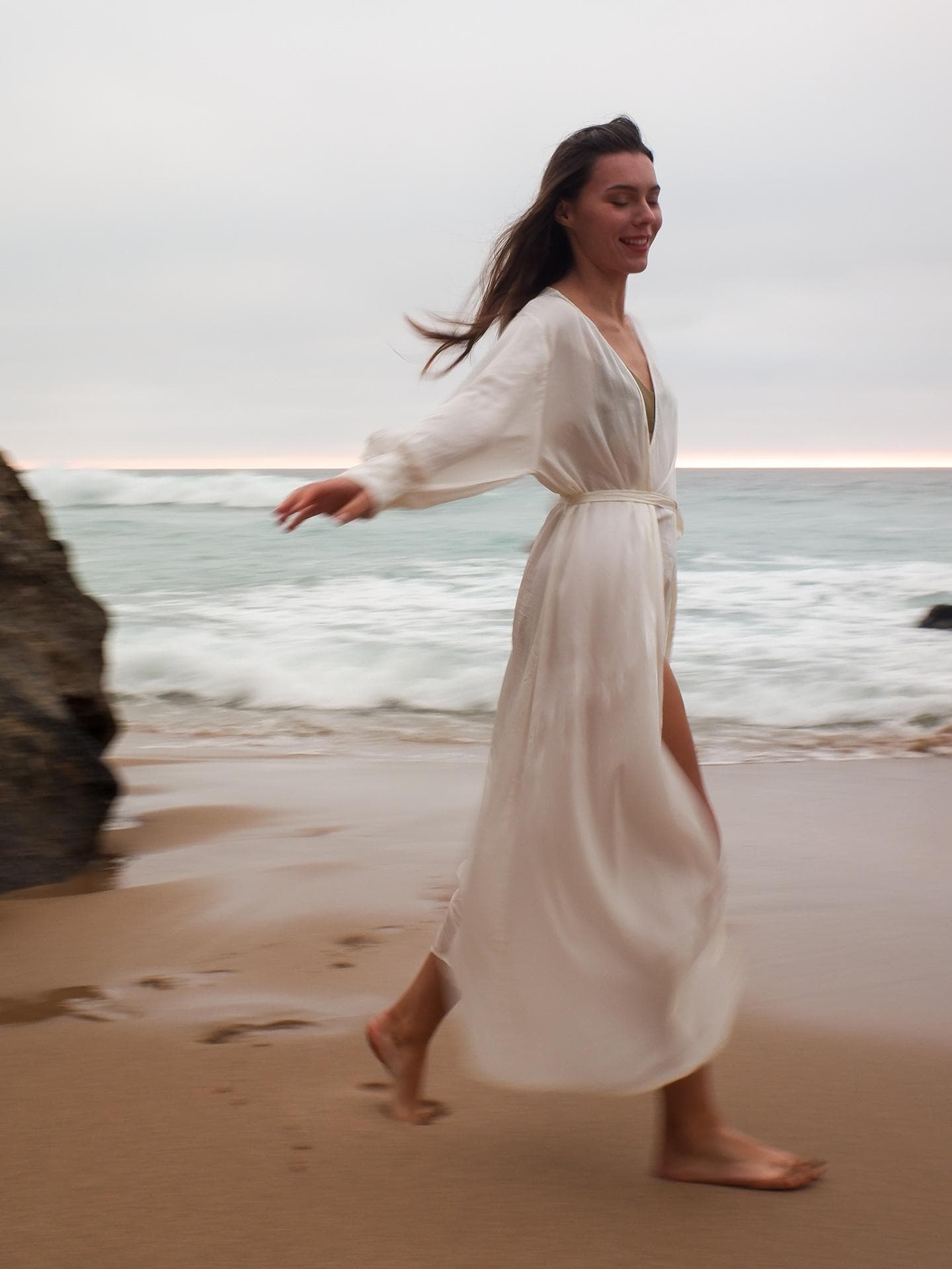 Frau steht am Strand