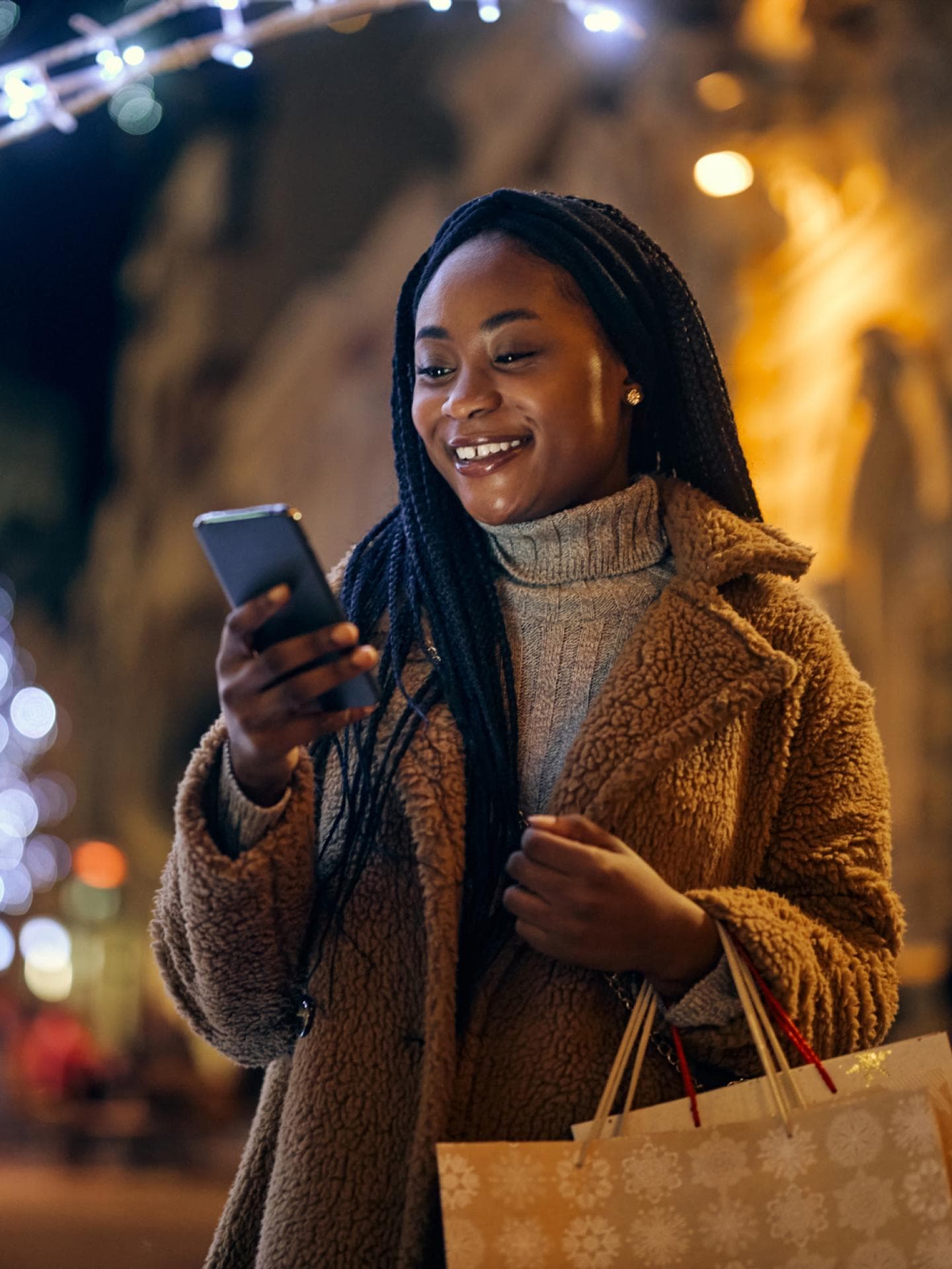 Frau schaut erfreut aufs Handy