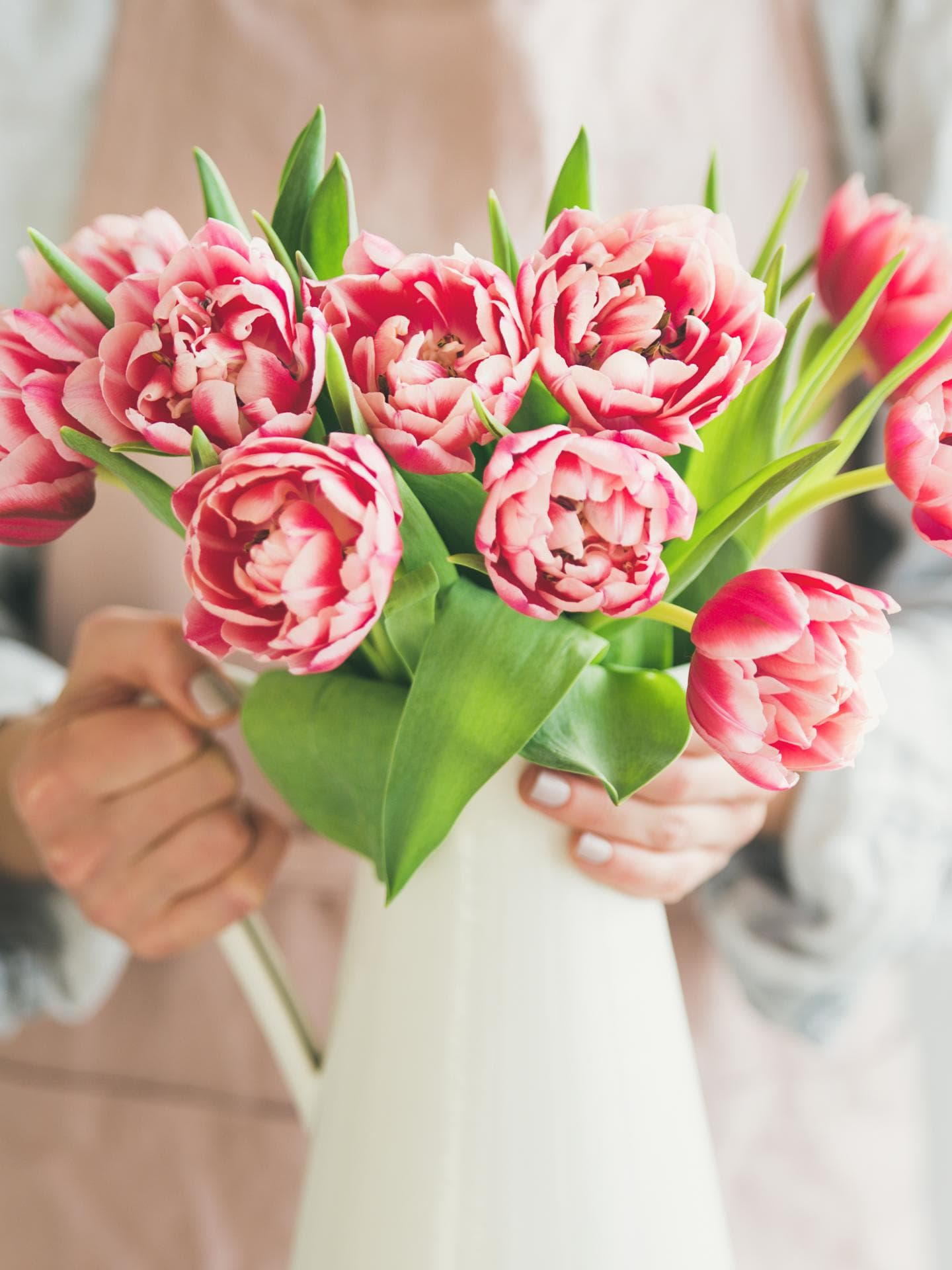 Frau drappiert Blumen in Vase