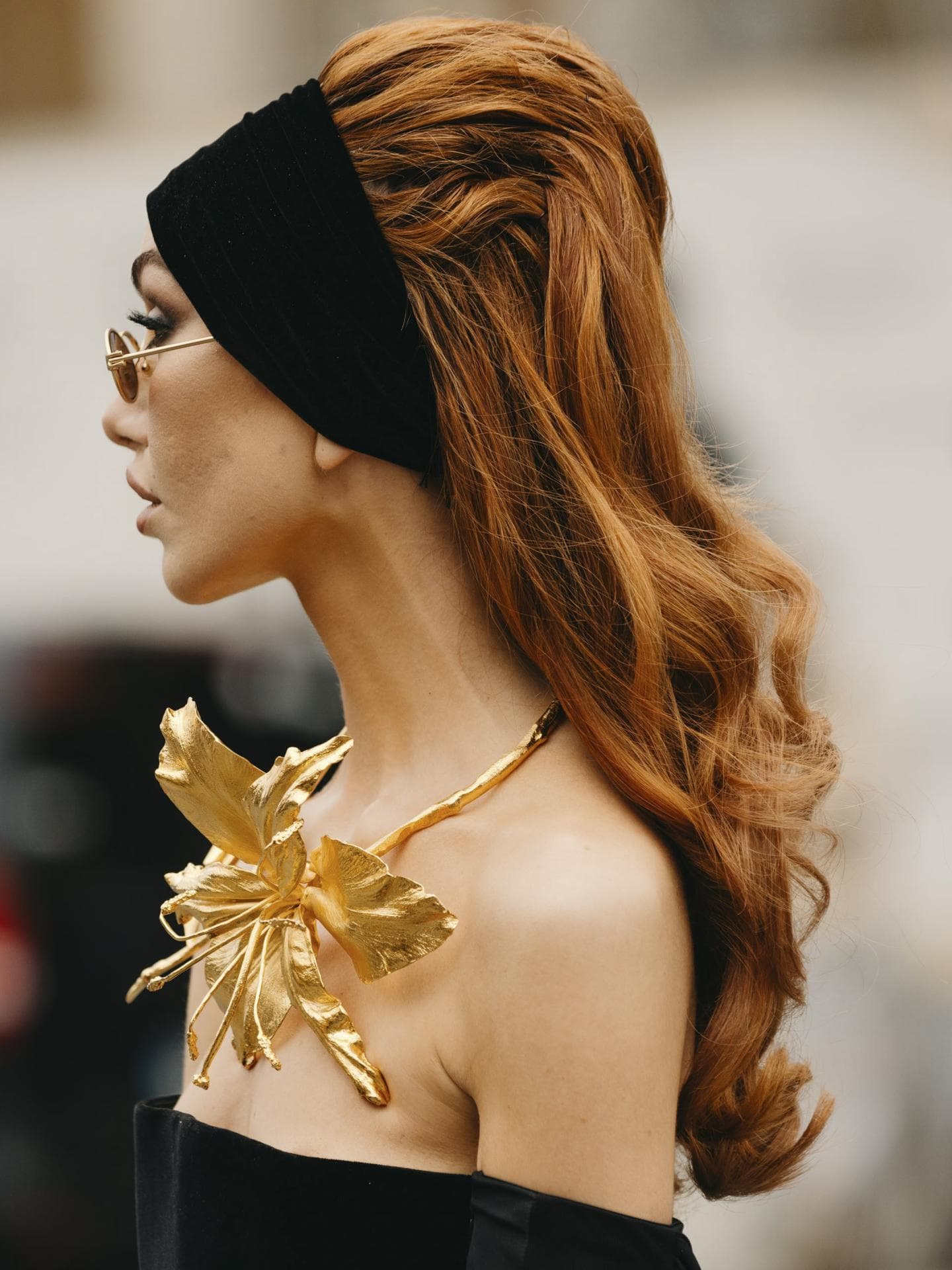 Frau auf Paris Haute Couture Fashion Week trägt schwarzes Kleid rote Haare Haarband Streetstyle