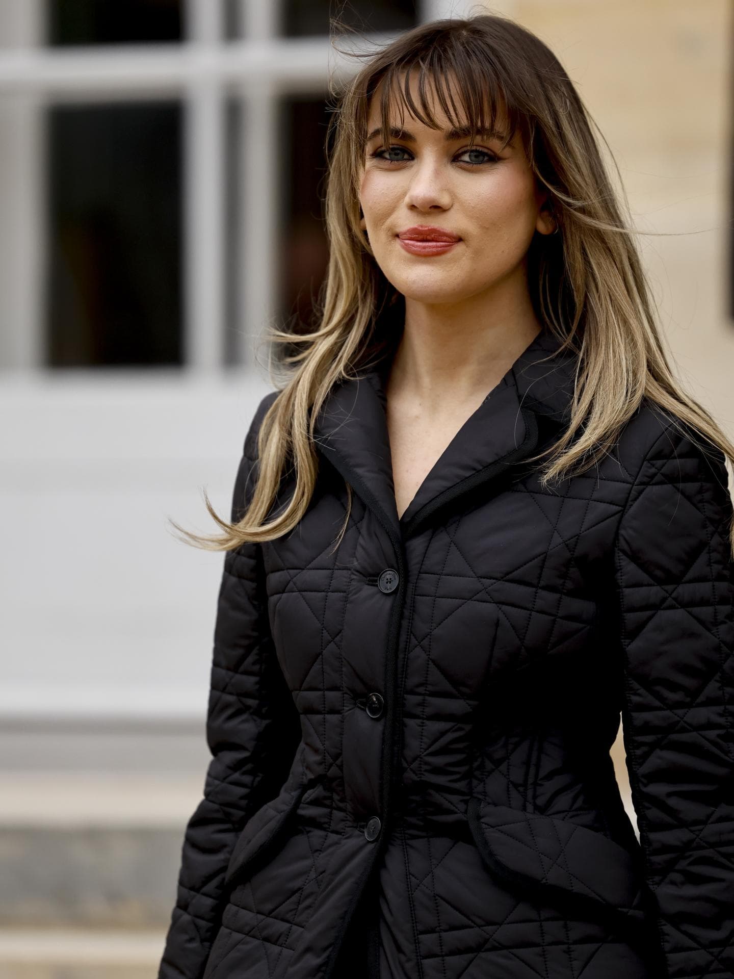 Frau trägt schwarze Jacke und Fox Cut auf Paris Fashion Week