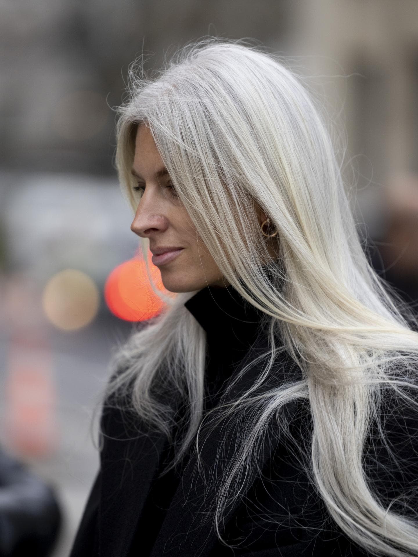 Frau trägt schwarzen Mantel und graue Haare mit Fox Cut