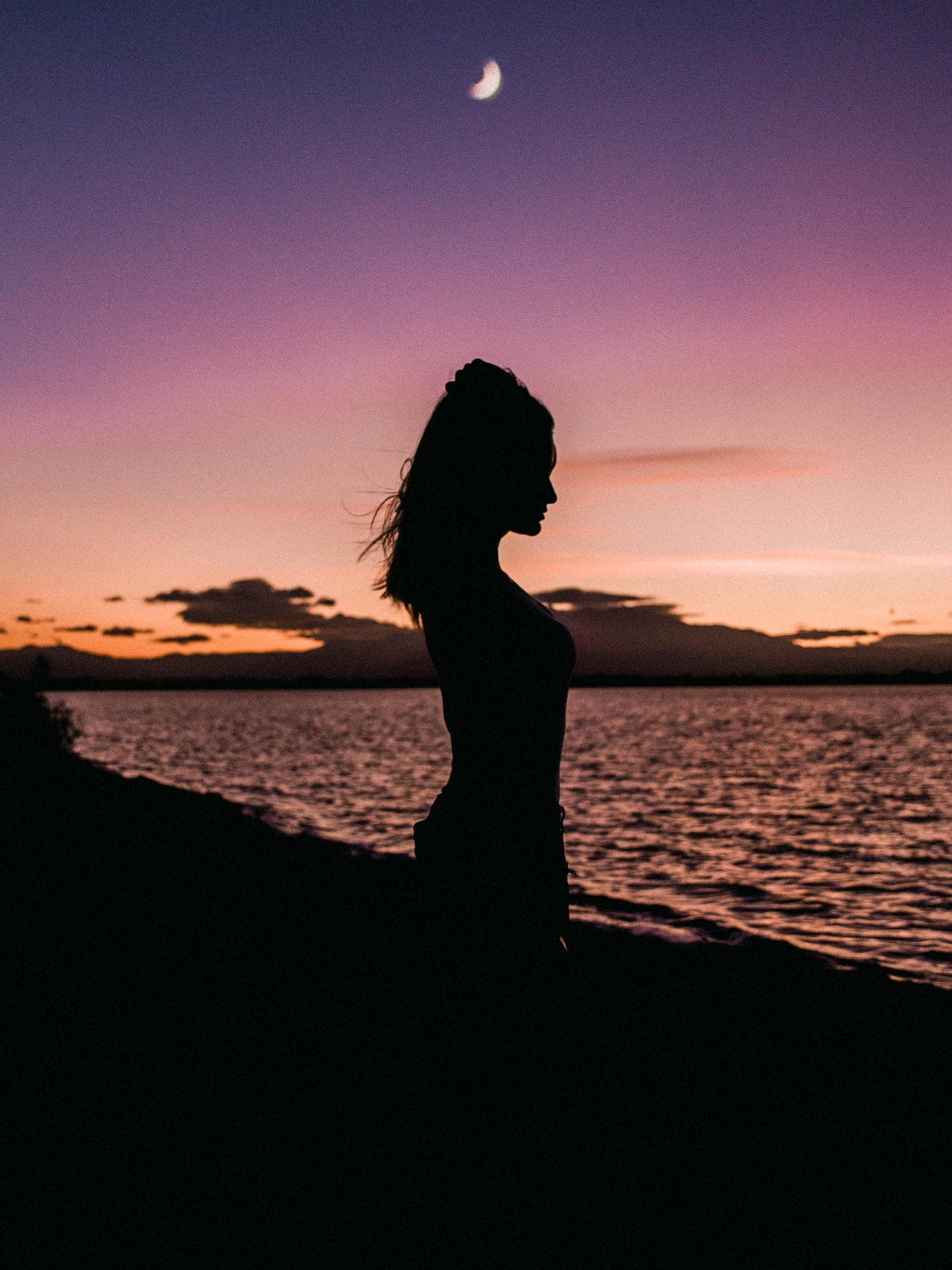 Frau mit Zopf steht am Wasser
