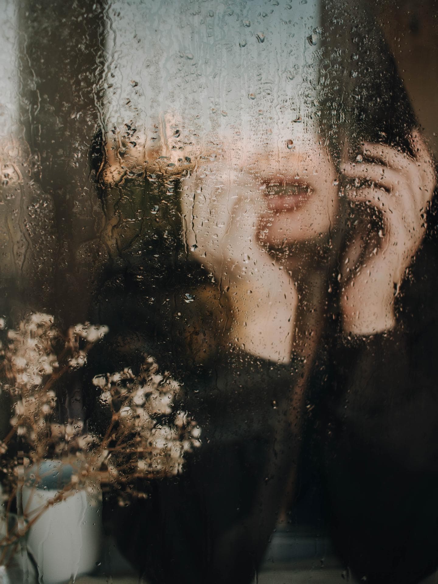 Frau am regnerischen Fenster