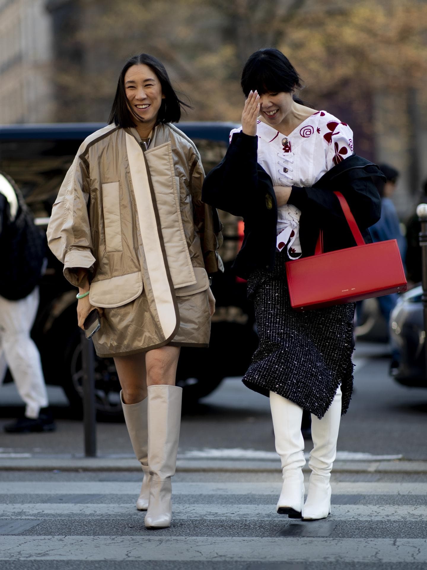Zwei Frauen tragen auf Paris Fashion Week kniehohe Stiefel mit Absatz
