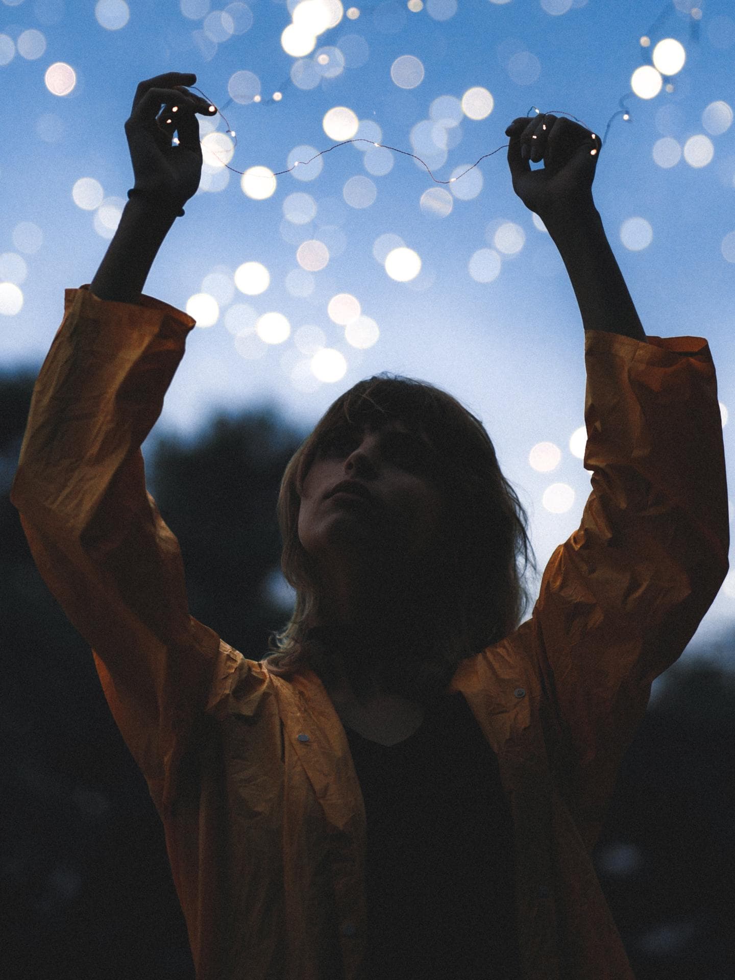 Frau hält eine Lichterkette in der Hand