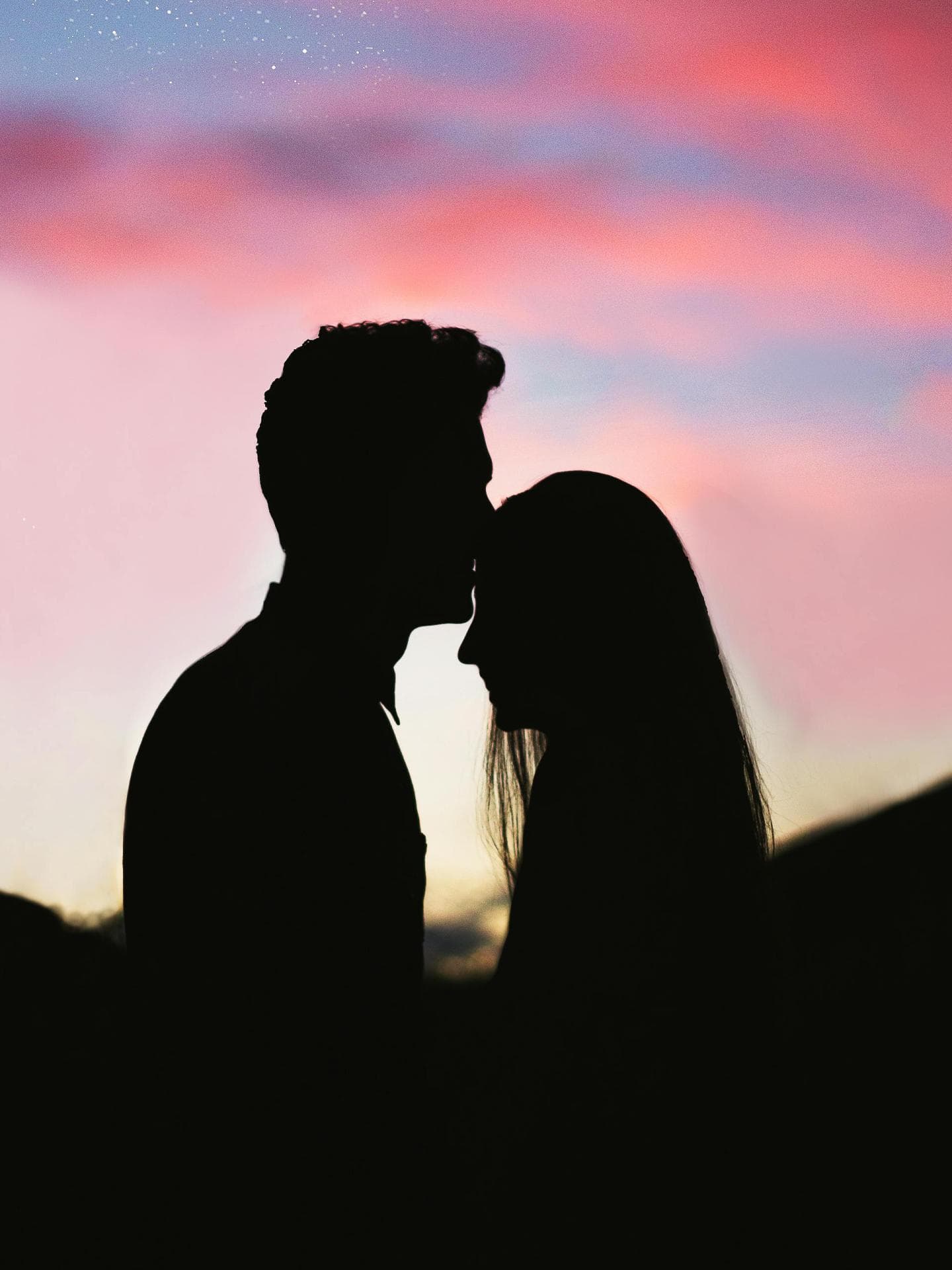 Mann küsst Frau auf die Stirn