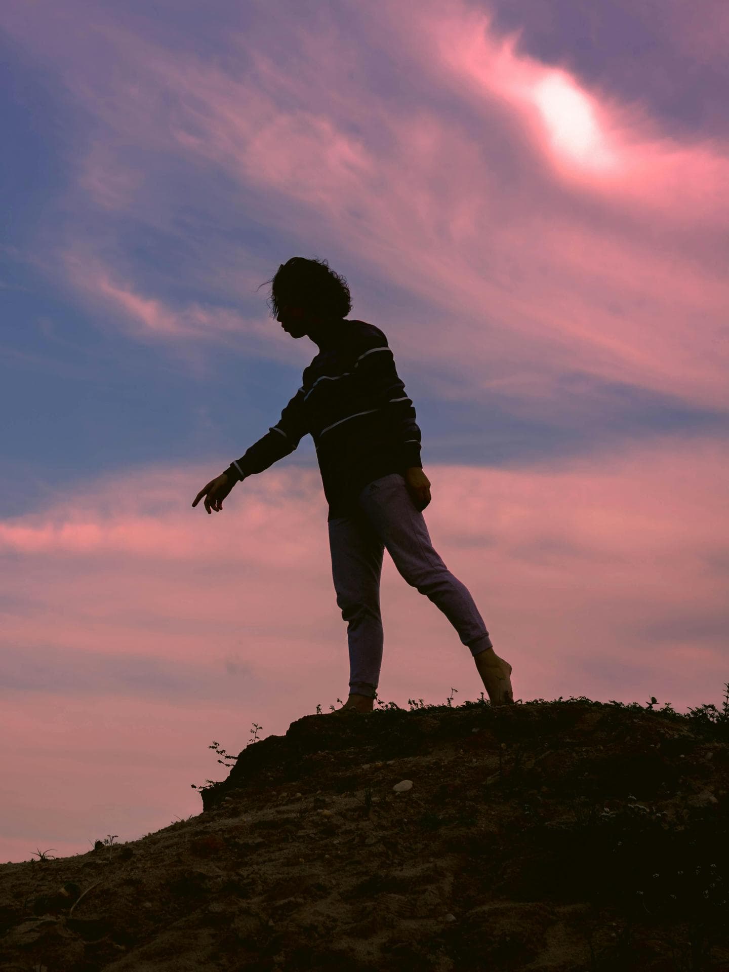 Silhouette einer Frau vor einem rosafarbenen Himmel