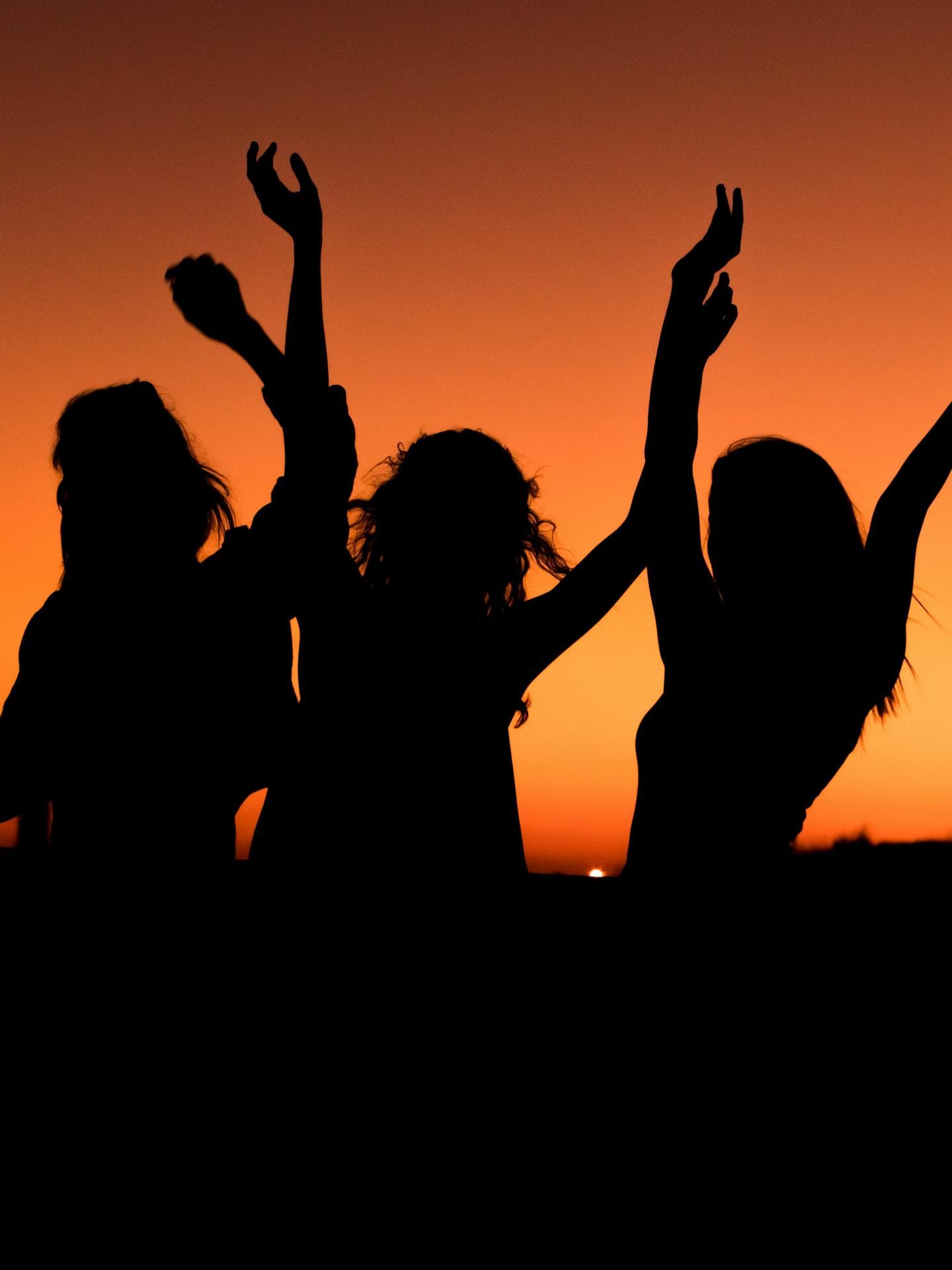 Wochenhoroskop Glueck Drei Silhouetten von Frauen vor Sonnenuntergang