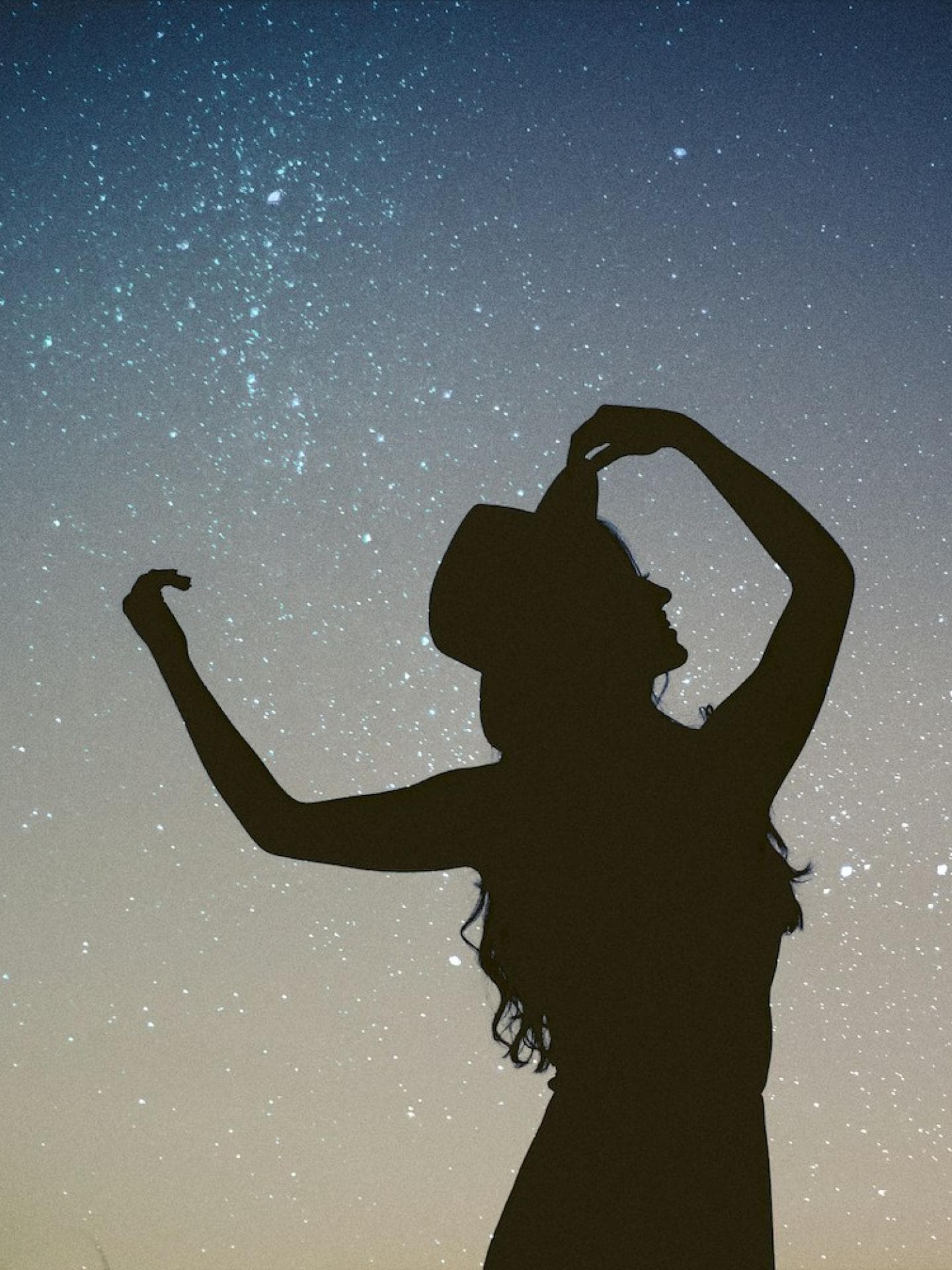 Frau tanzt unterm Sternenhimmel
