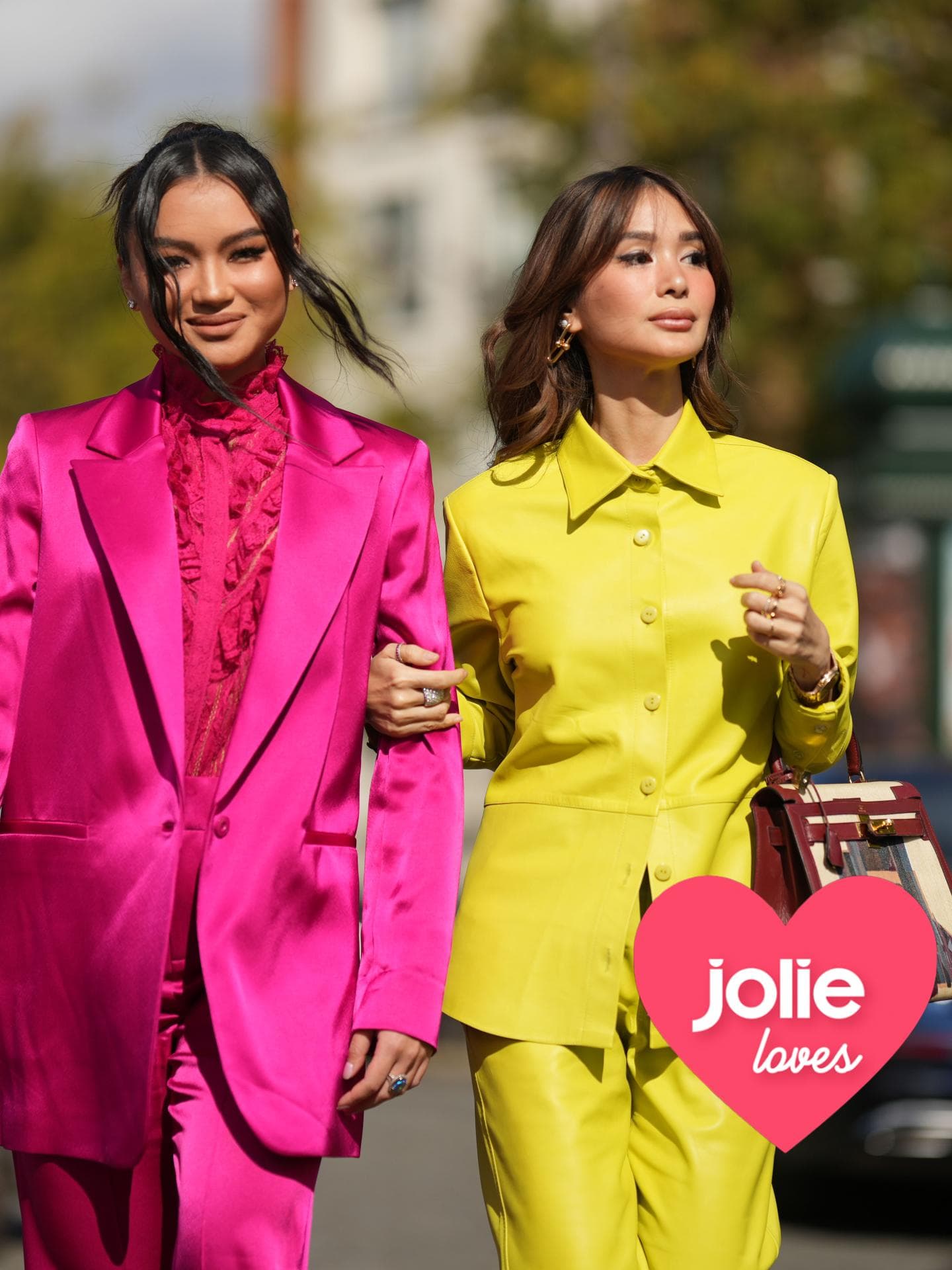 Jolie Loves Frauen in bunten Anzügen gehen durch die Straße