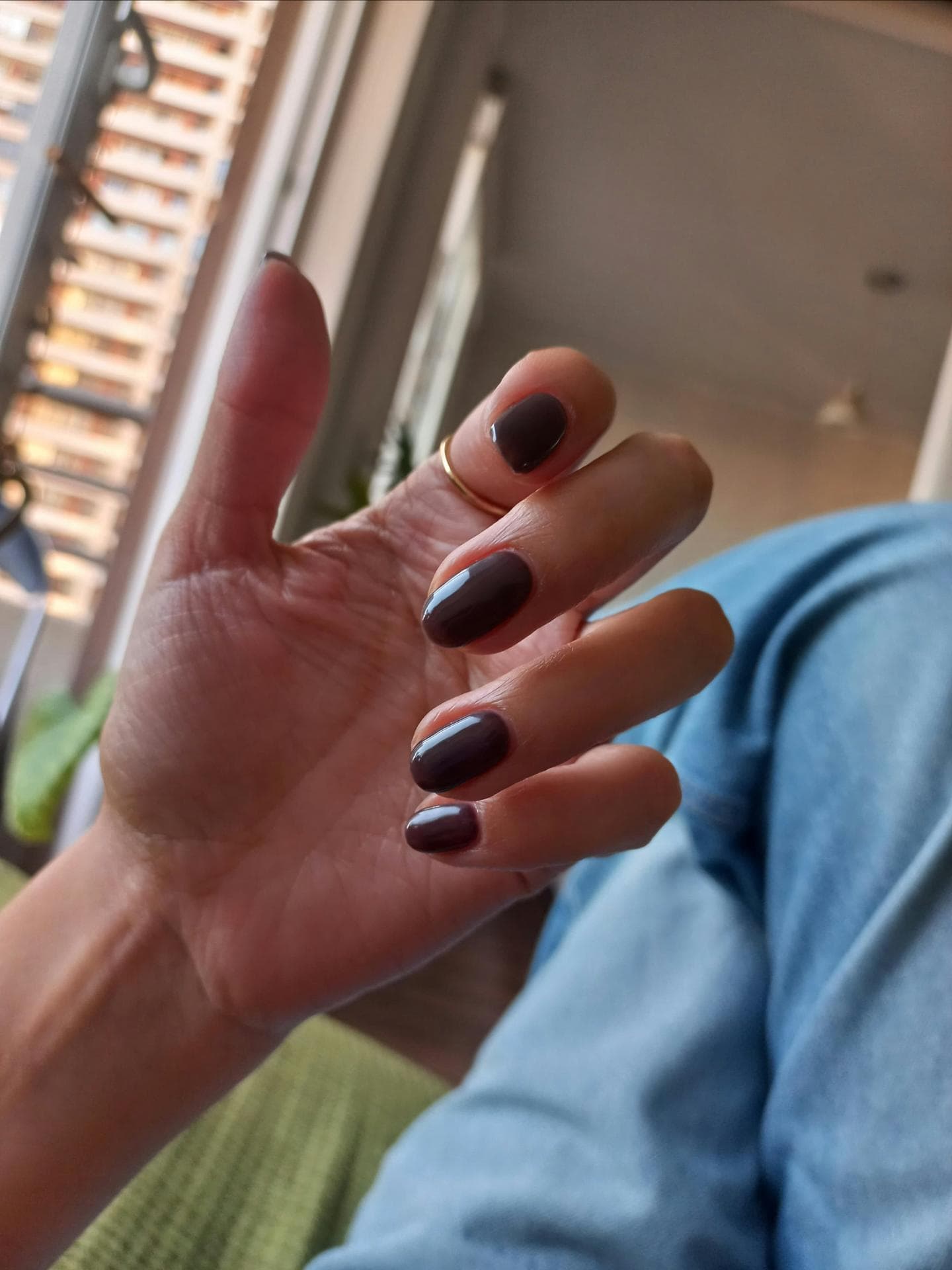 Nägel mit dunkelbrauner Farbe lackiert