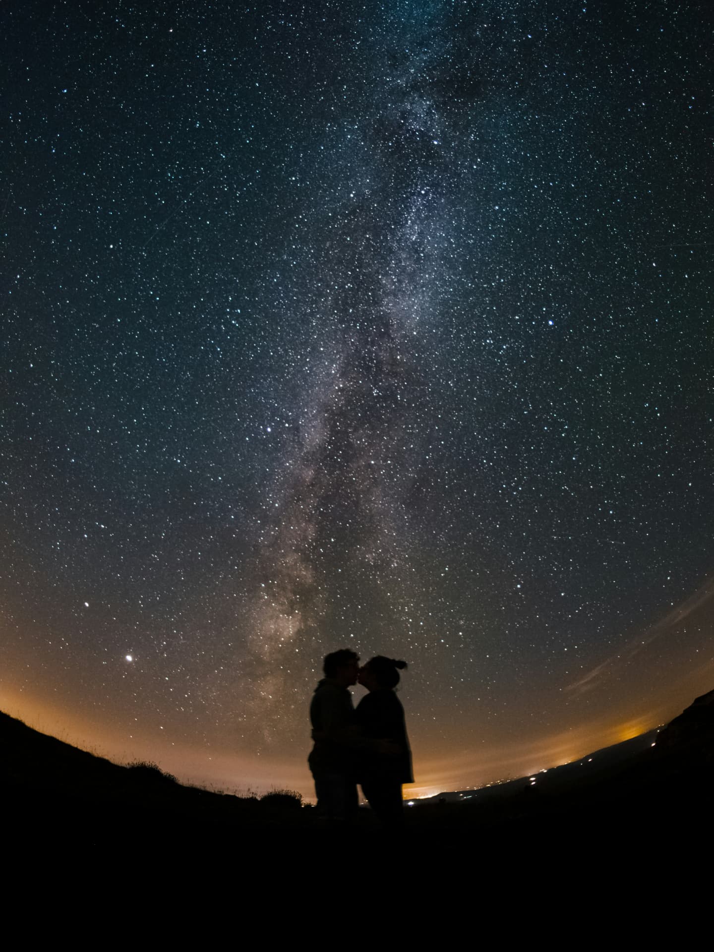 Welche Sternzeichen jetzt Liebesglück erwartet? Das liest du hier. Paar küsst sich unter Sternenhimmel