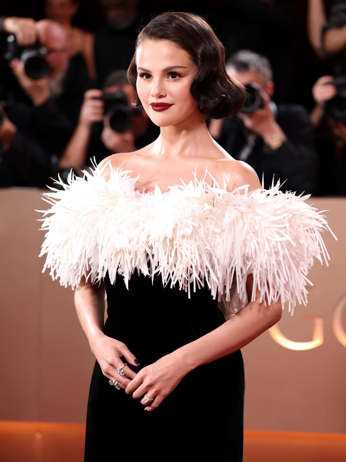 Selena Gomez mit einem Bob und einer voluminösen Robe in Schwarz und Weiß.