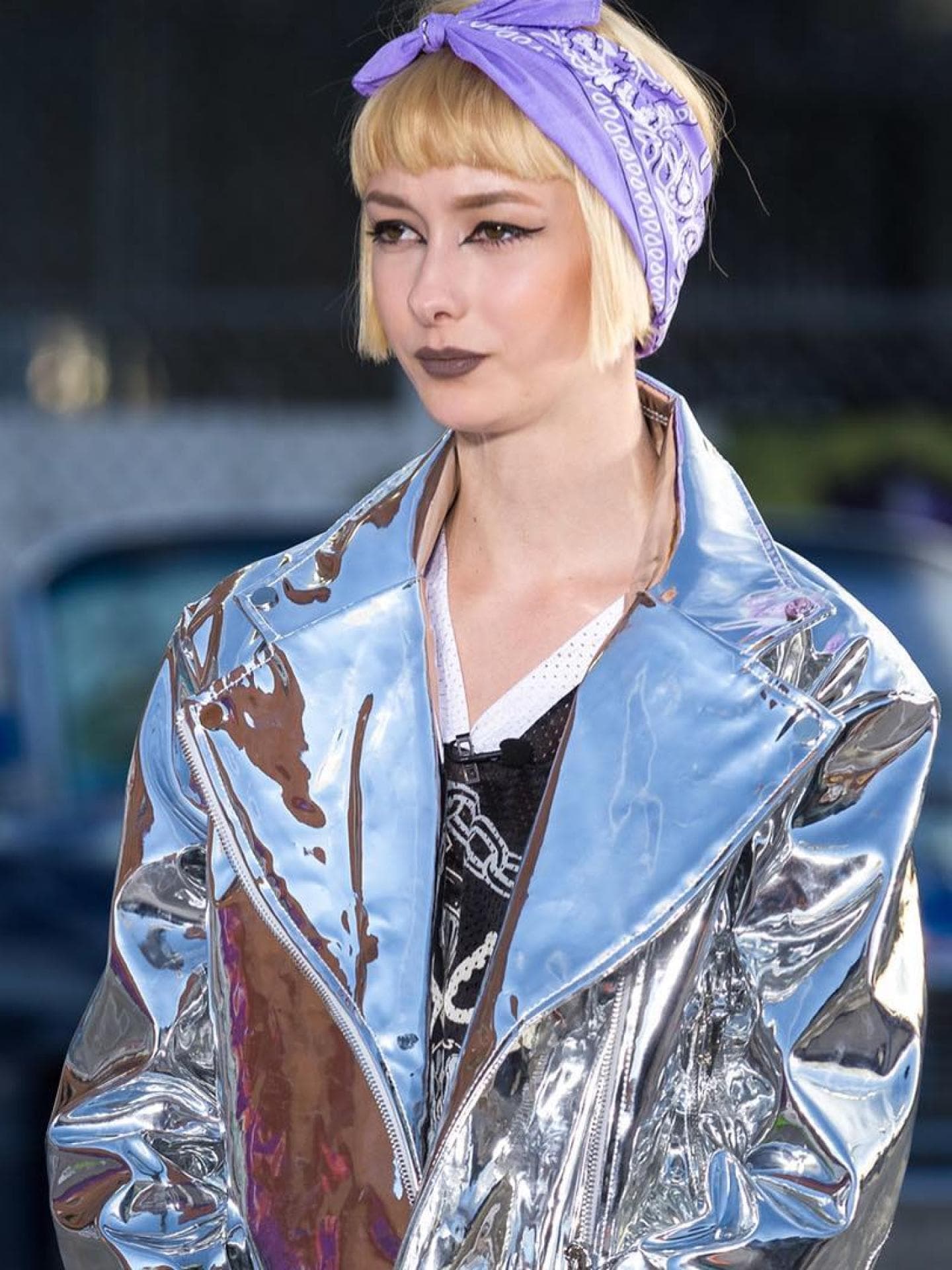 Sally bekam bei GNTM einen blonden Kurzhaarschnitt. Sally von GNTM mit einer spiegelnden Jacke und einem Lila Bandana.