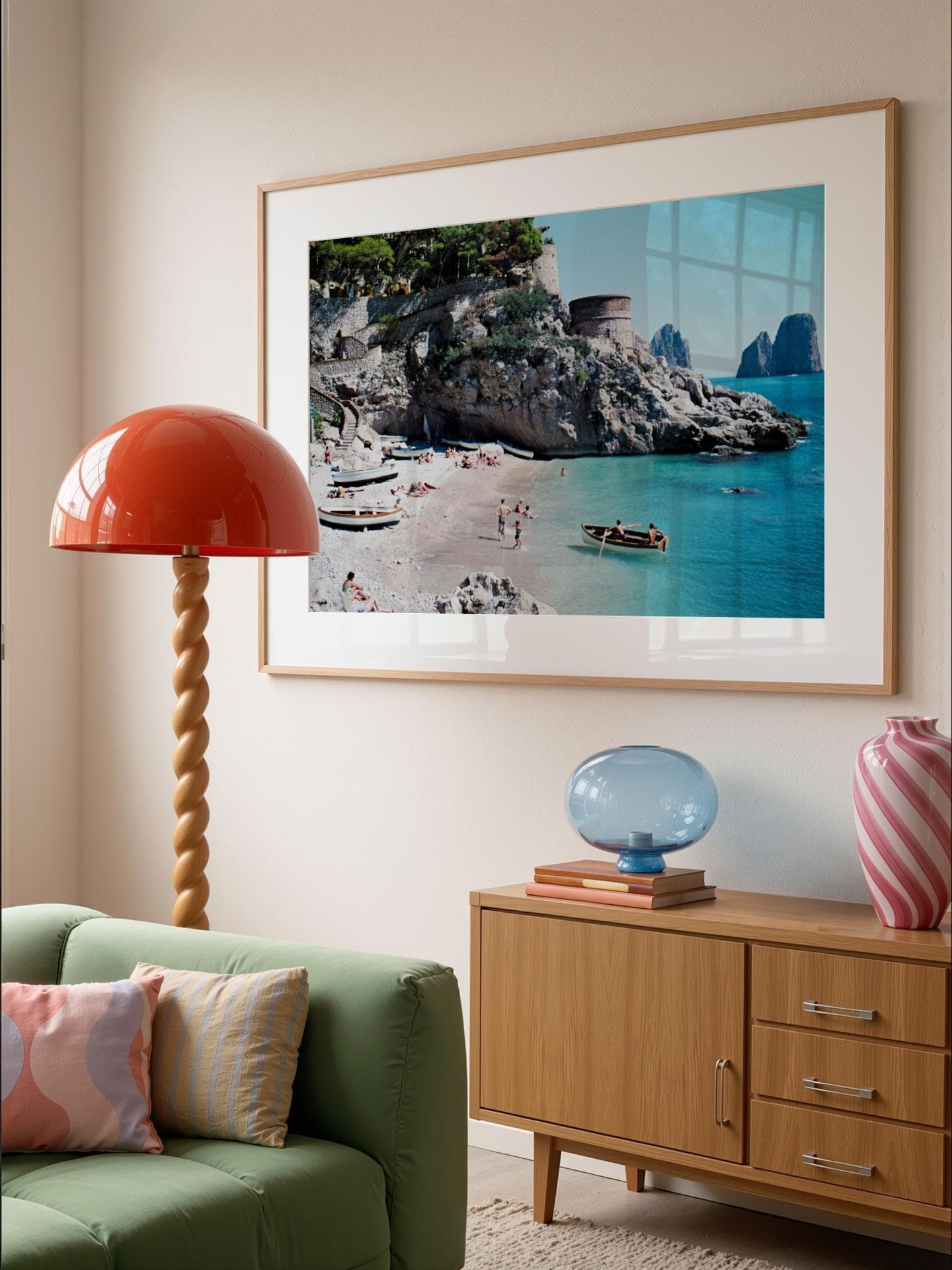 Ein Wohnzimmer mit einem gerahmten Print an der Wand, einem Sofa, einer Stehlampe und einer Kommode.