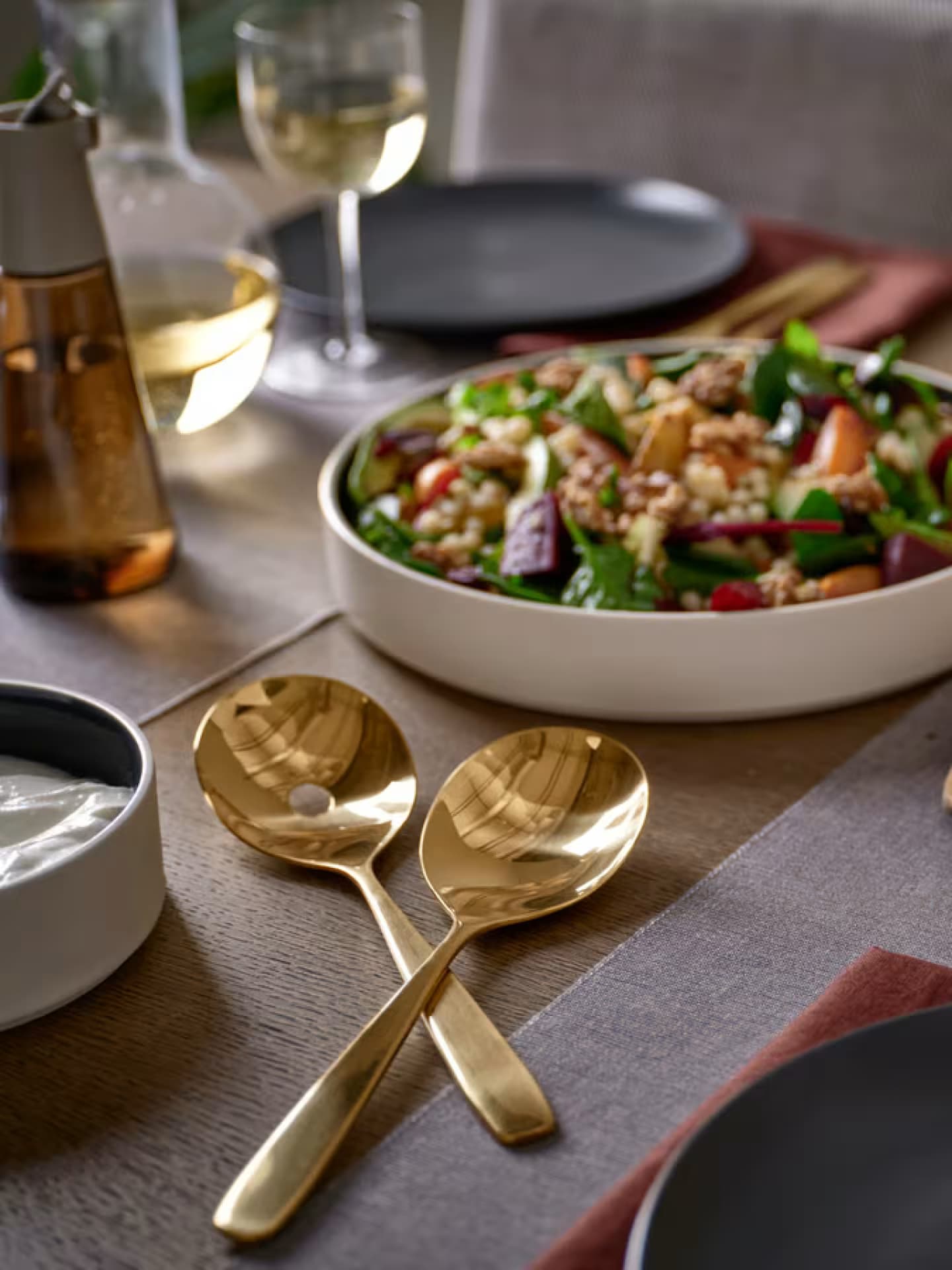 Goldenes Besteck ist eine tolle Abwechslung auf dem gedeckten Tisch. Ein gedeckter Tisch mit einem Salat und goldenem Salatbesteck.