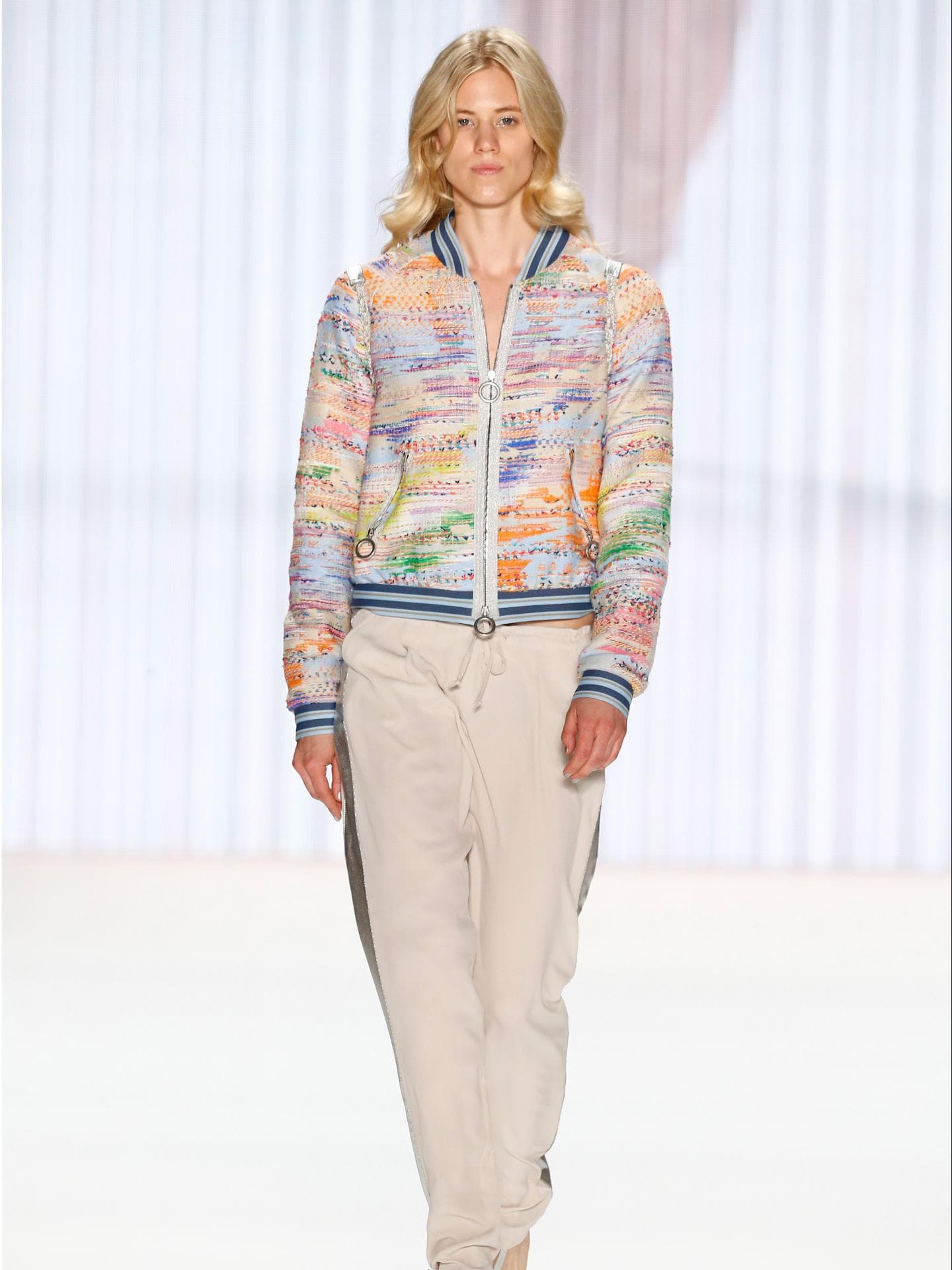 Larissa Marolt auf dem Laufsteg für Riani Spring/Summer 2016 in einer beigefarbenen Hose und einer bunten Jacke.