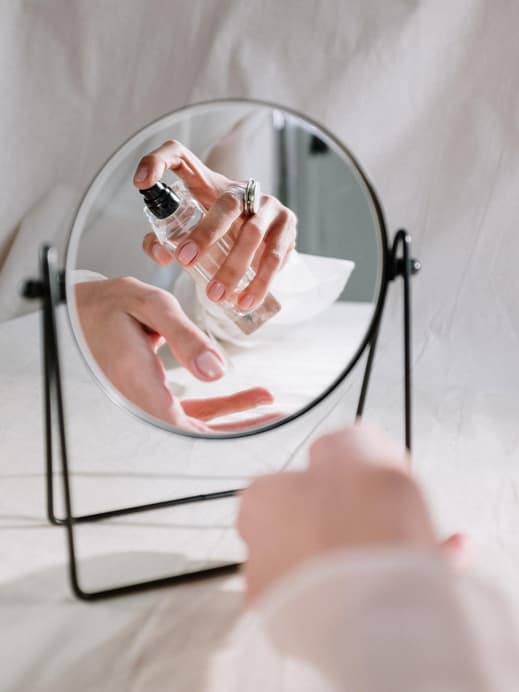 Frau sprüht Parfum auf