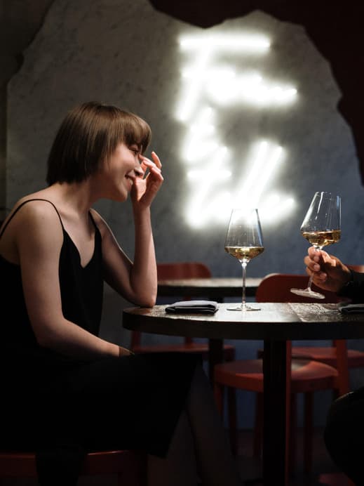 Paar beim ersten Date sitzt an einem Tisch und trinkt Wein.