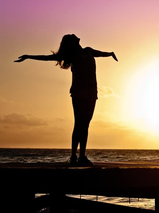 Silhouette einer Frau vor dem Sonnenaufgang