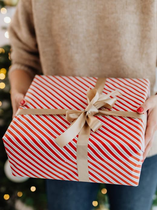 Person mit Geschenk in der Hand