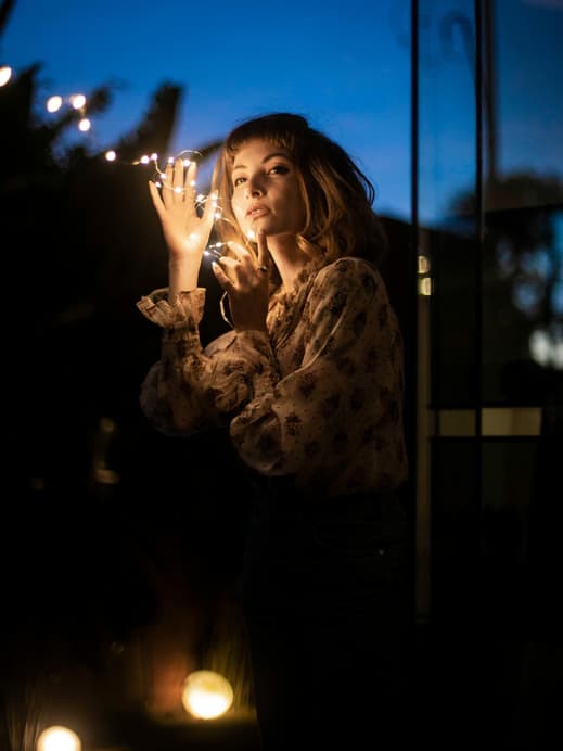Frau hält Lichterkette in der Hand