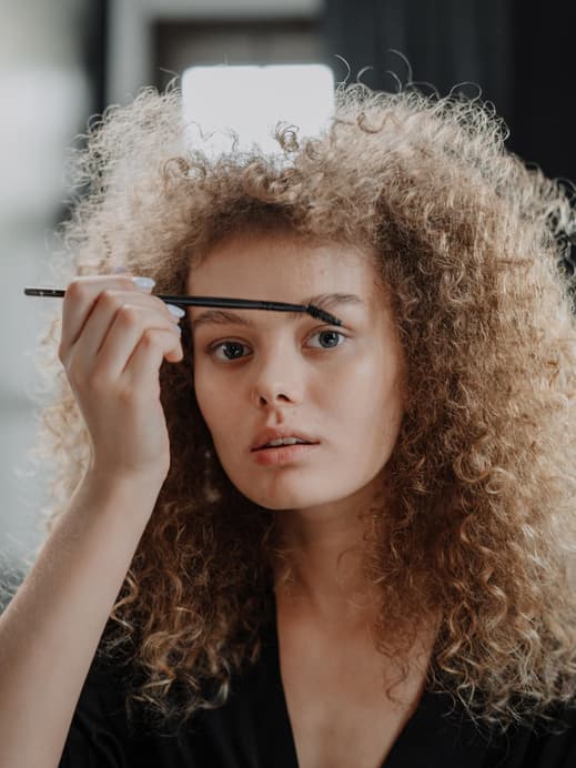 Frau schminkt sich Augenbrauen