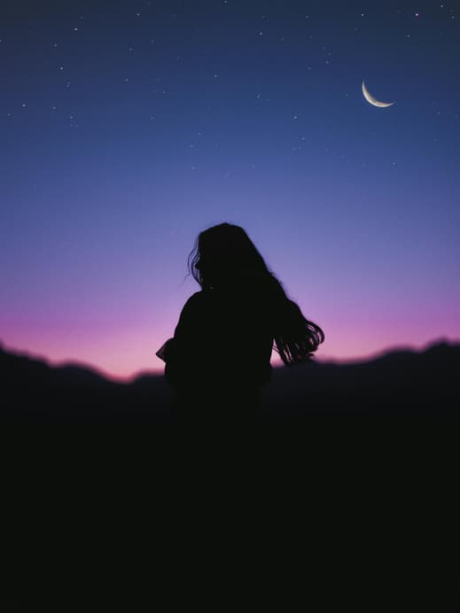 Frau steht vor Sternenhimmel