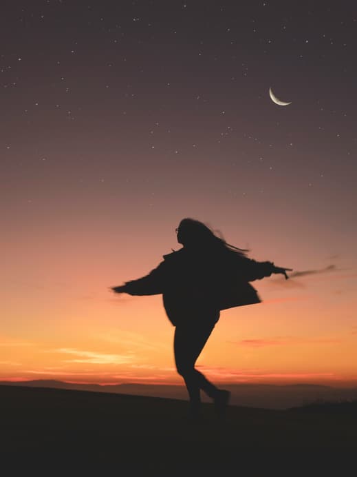 Frau tanzt unter Sternenhimmel