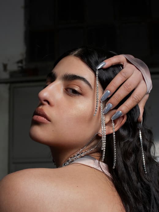 Frau mit silbernen Fingernägeln und Ketten