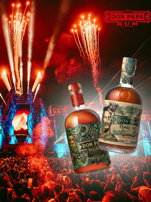 Eine Festivalbühne mit Feuerwerk und vielen Menschen davor, außerdem zwei Flaschen von Don Papa Rum darübergelegt.
