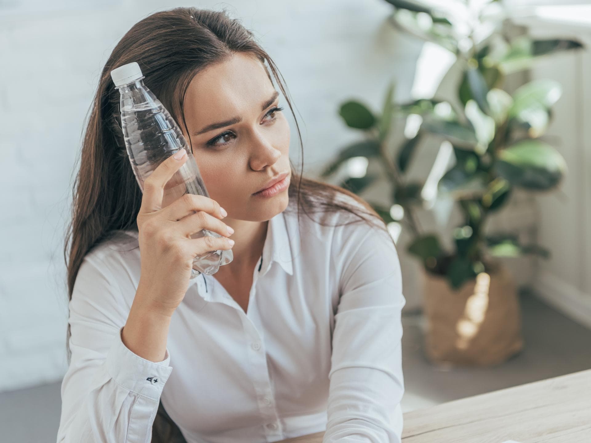 frau im büro mit wasserflasche