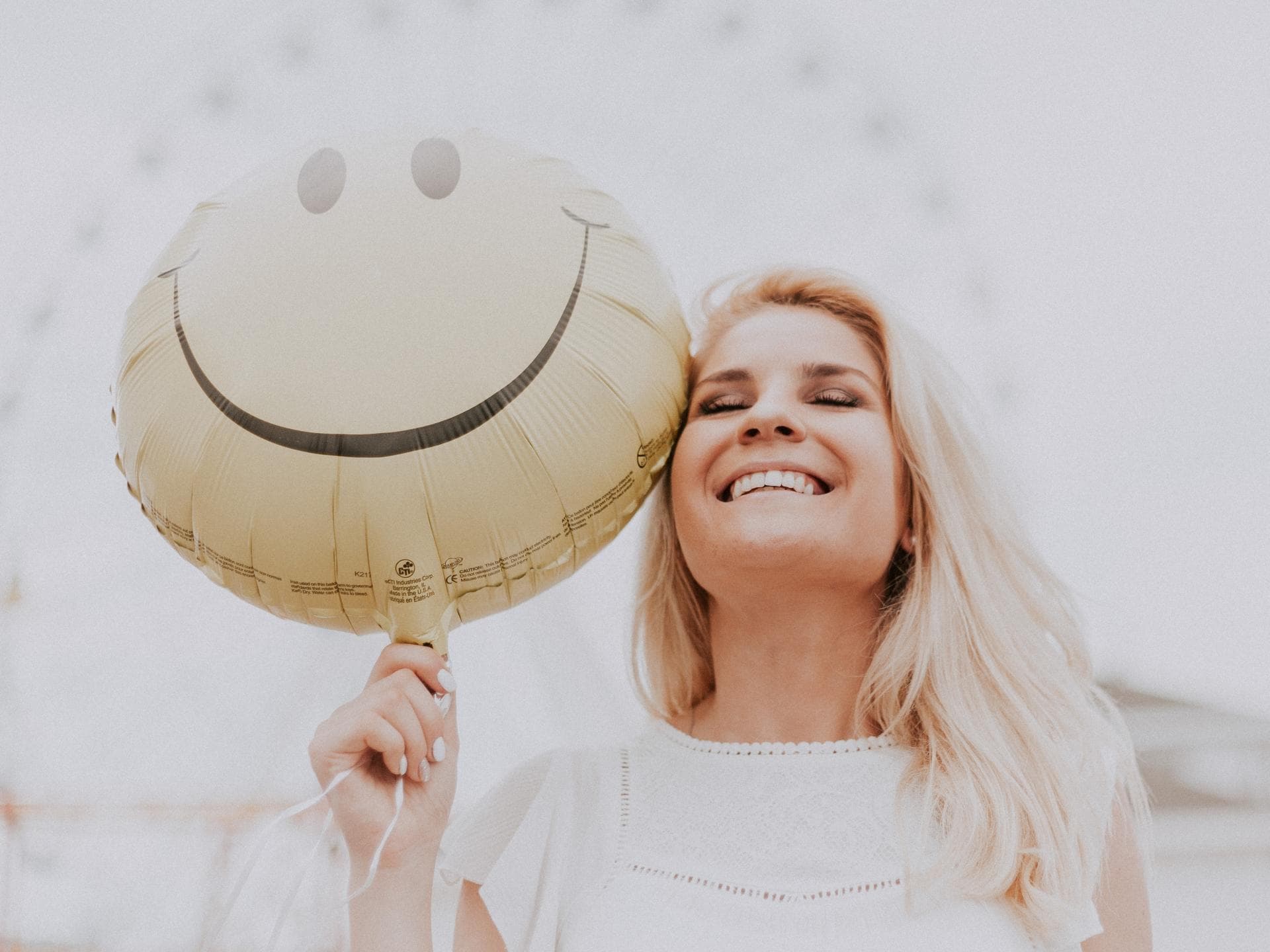 Horoskop: Frau lacht mit Luftballon