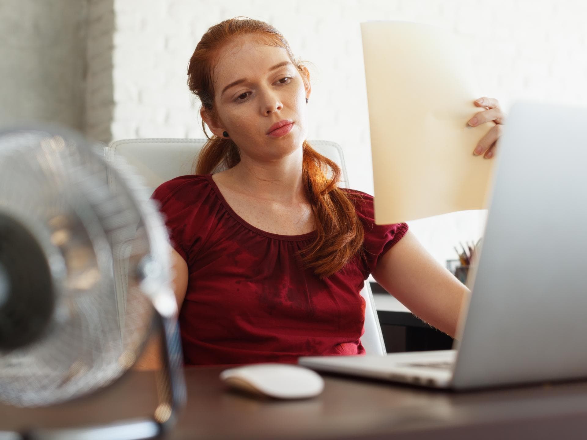 Blogartikel: Hitze im Büro Frau im Büro bei Hitze