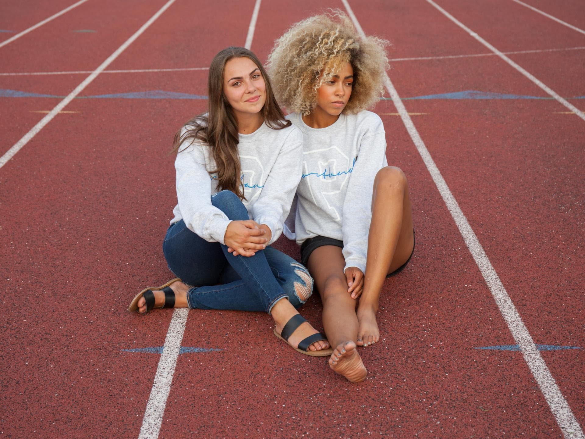 Frauen sitzen auf Sportplatz