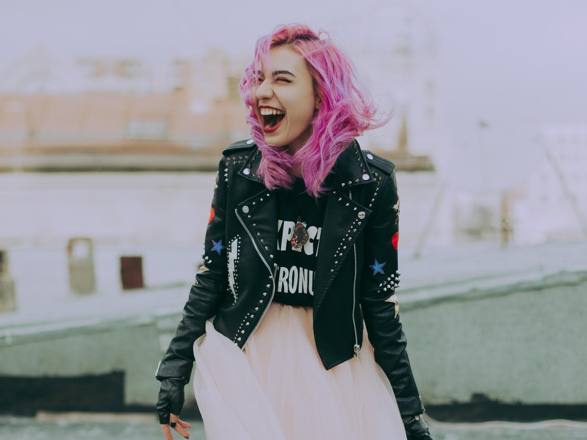 Horoskop Horoskop: Frau lacht mit rosa Haaren
