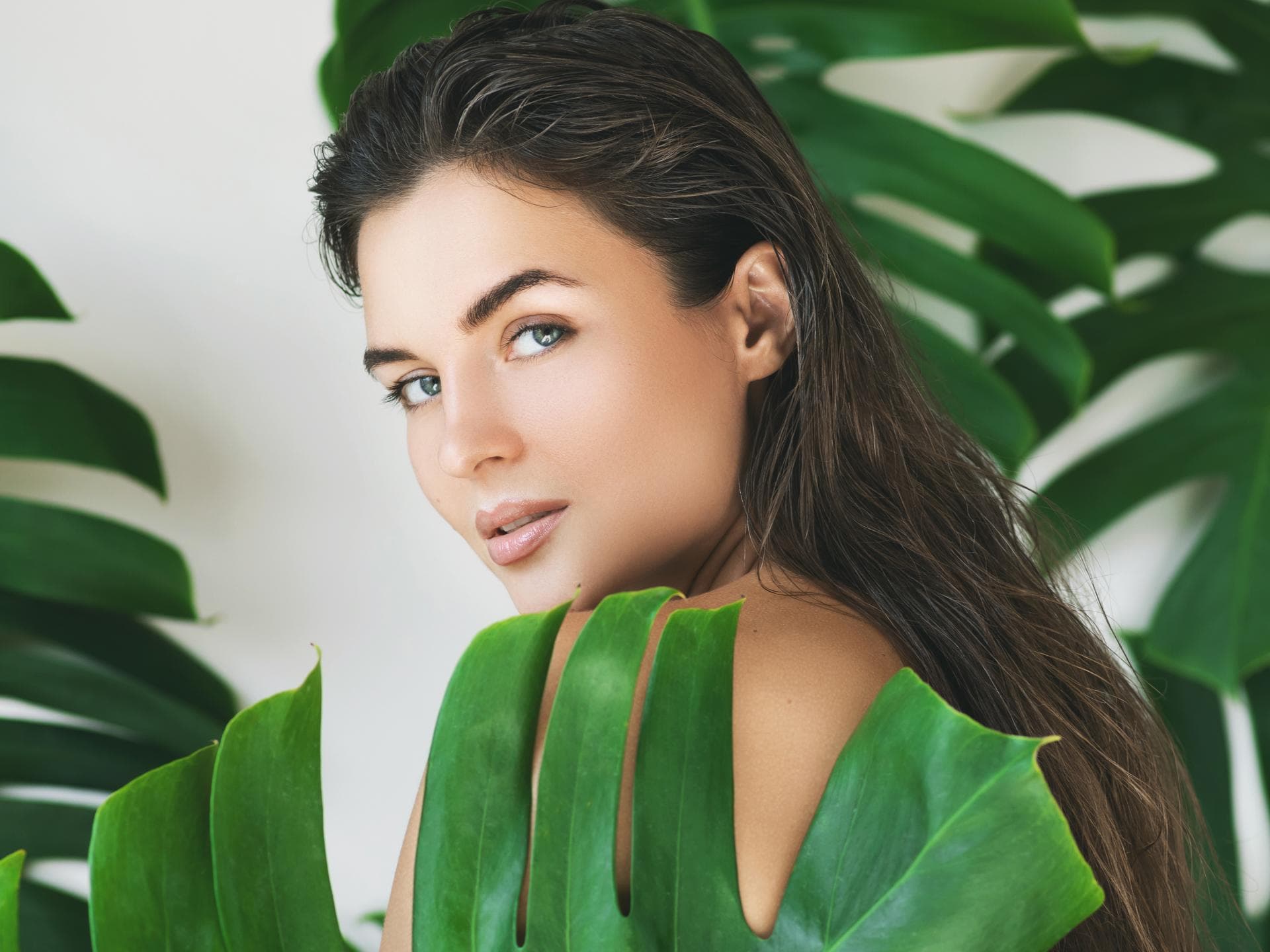 Brau mit Monstera-Blättern und schöner Haut