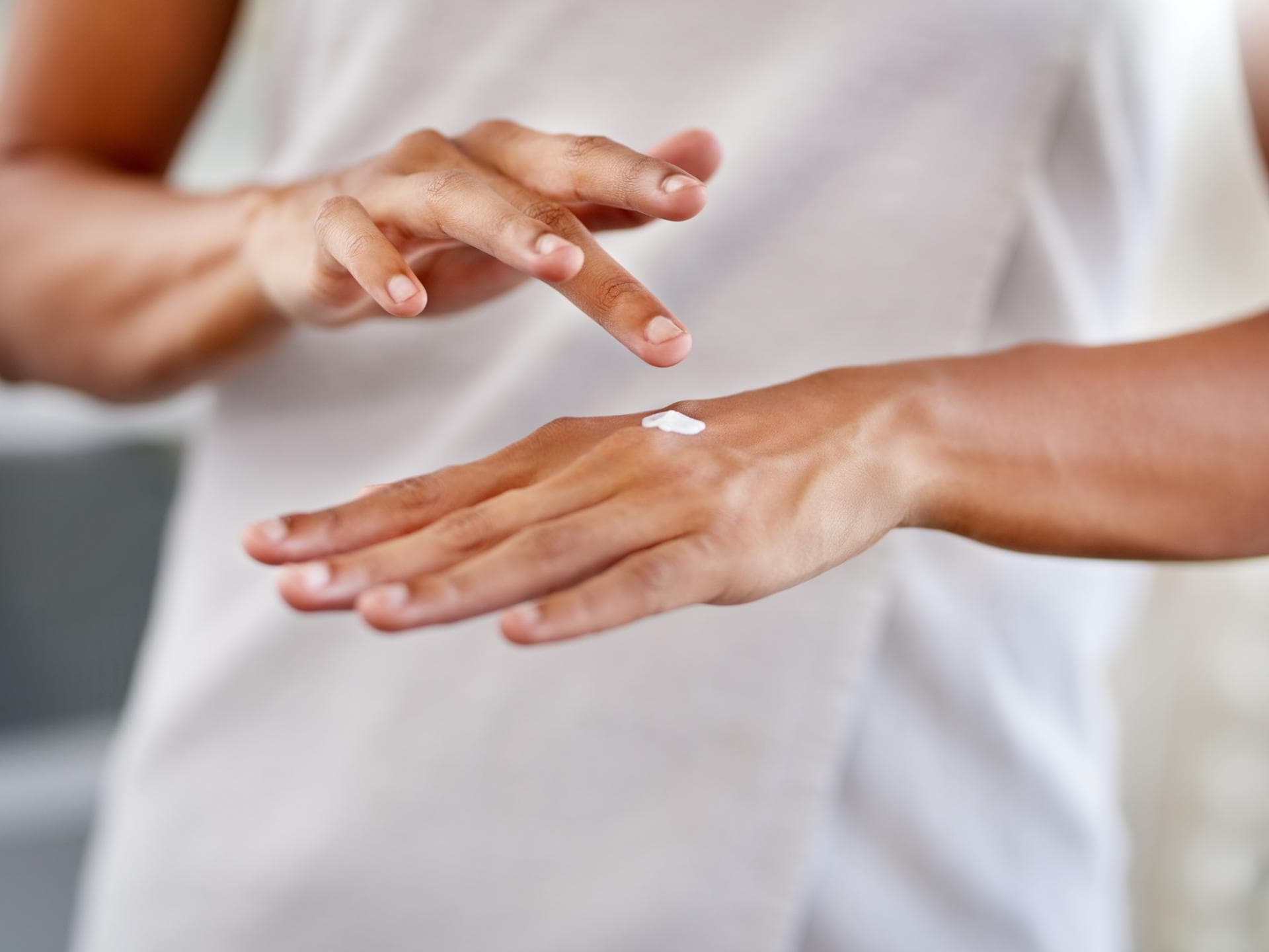 frau mit handcreme cremt hände ein