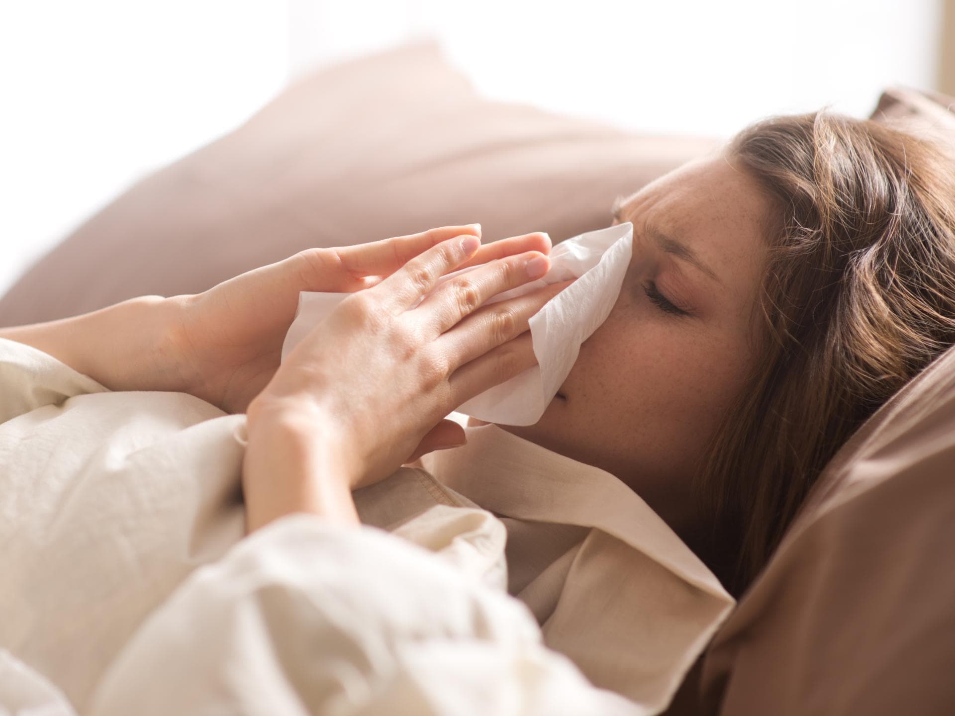 Frau liegt krank im Bett
