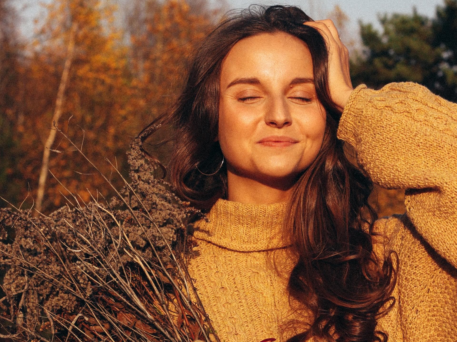 Horoskop Thema Horoskop: Frau mit gelbem Pullover und getrockneten Blumen