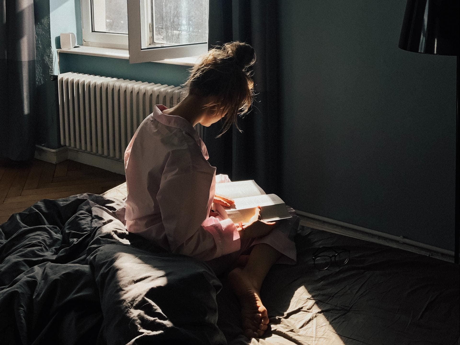 Mädchen auf Bett mit Buch