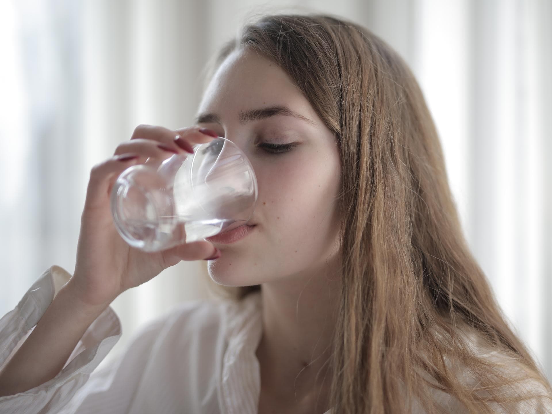 Immunsystem mit Gesundheitswasser stärken Frau trinkt aus Glas