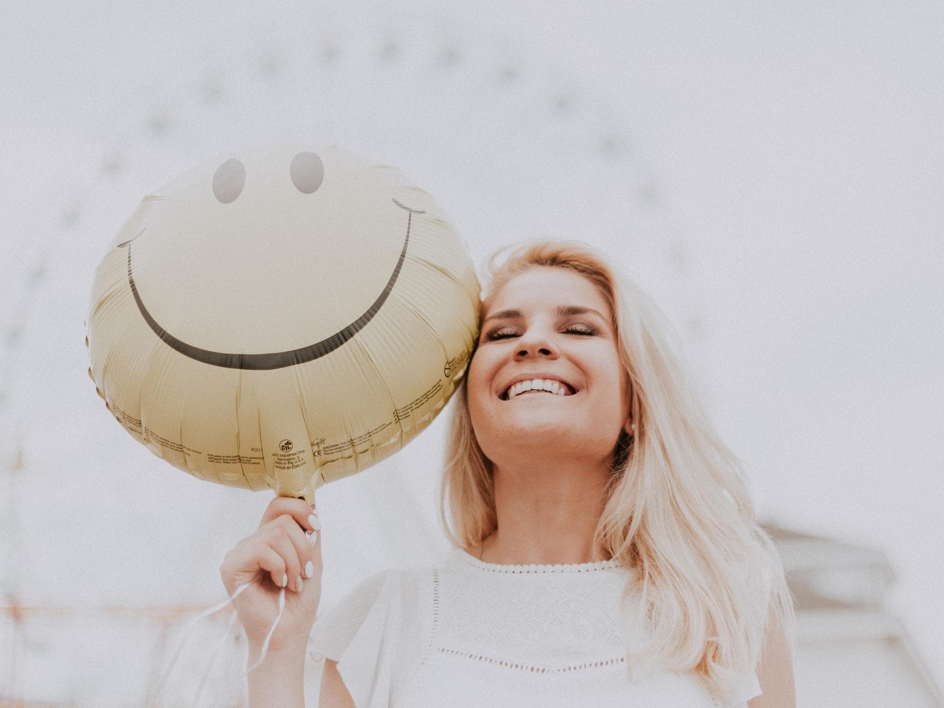 Frau lacht mit Ballon